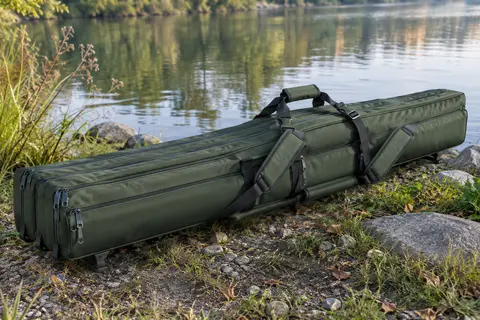 Fourreau vert à trois compartiments posé au bord de l’eau, avec poignées et bretelles de portage.